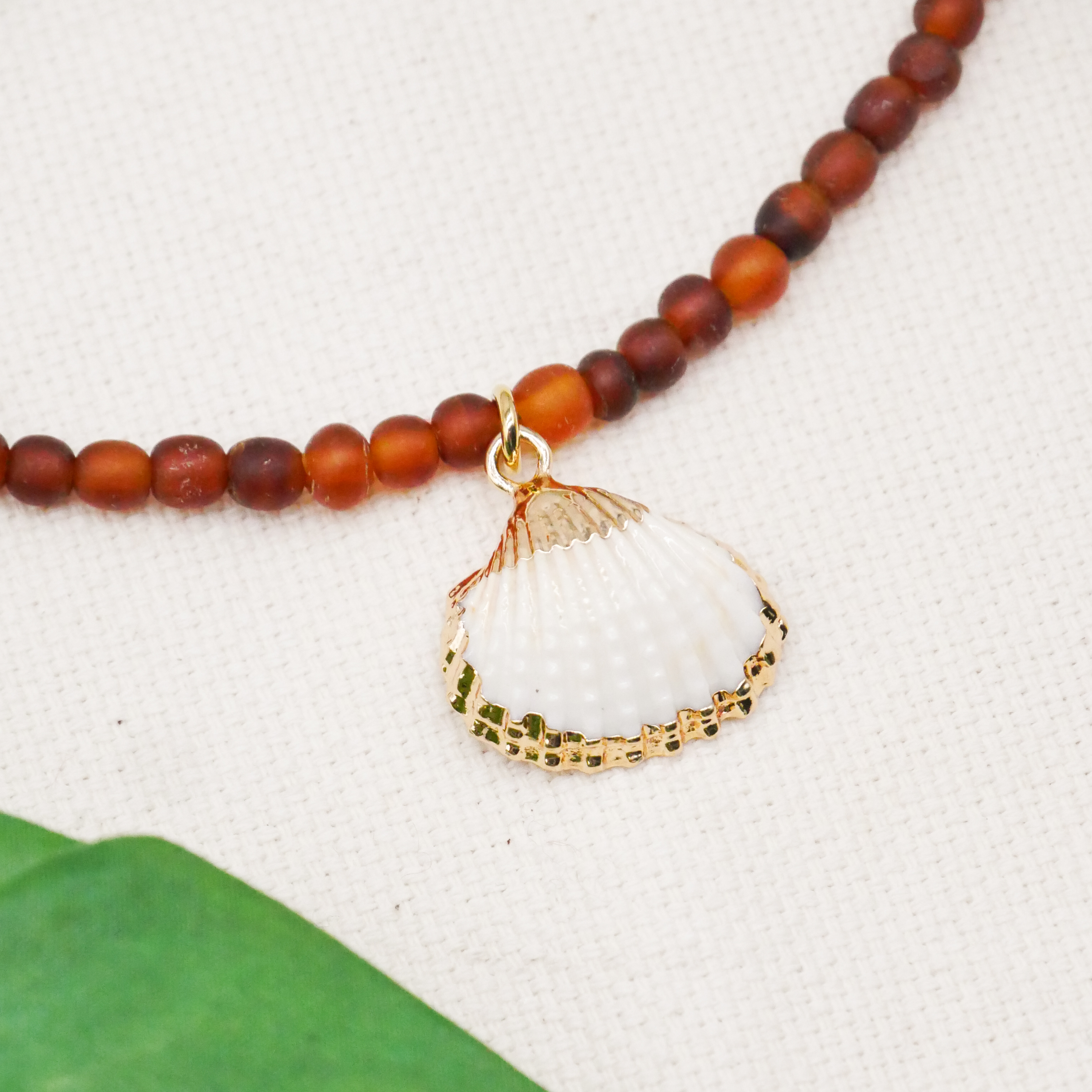 "Shell" kurze Kette, kleine Carabo Horn Perlen Ø ca. 5 mm, dunkles braun, Muschelanhänger 