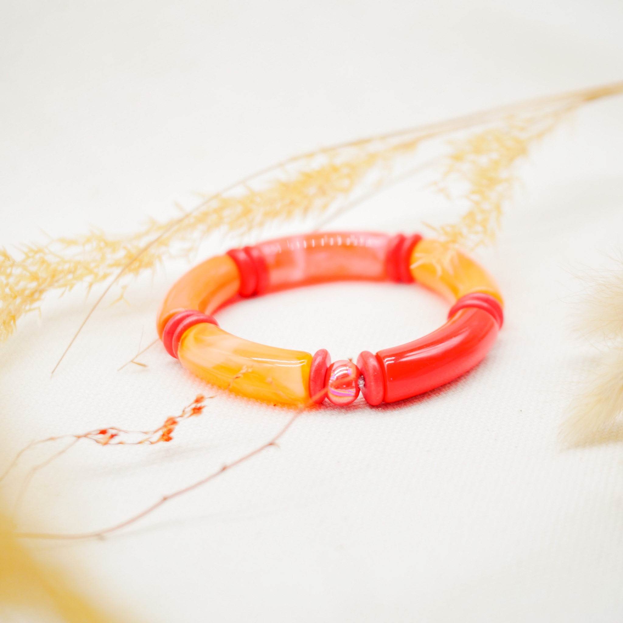 Bracelet "tube" on elastic string, curved plastic pearls + howite, orange