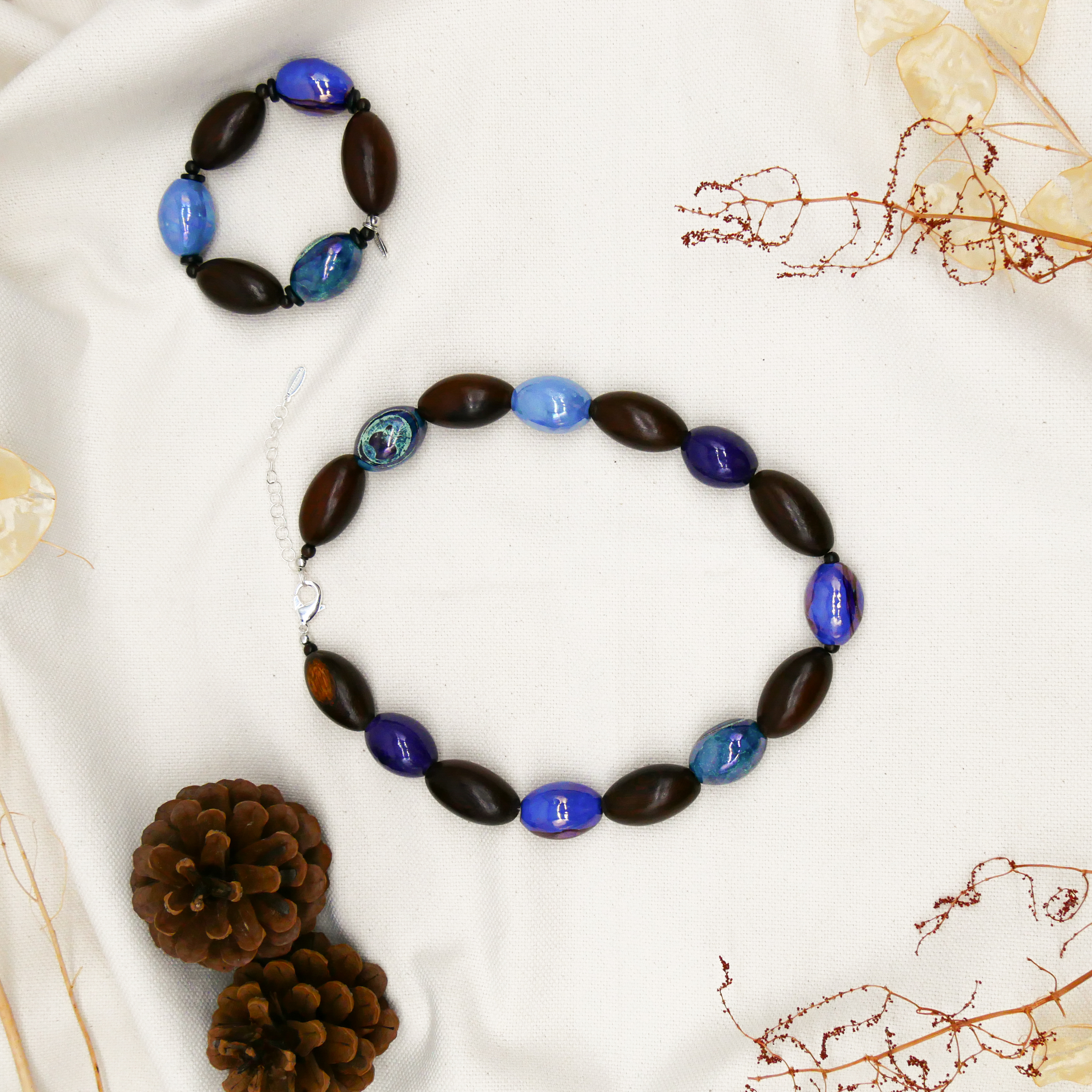 "Woodland" Armband auf Gummi "Olive", Robles Holzoliven und Keramikoliven, braune und blaue Töne "Woodland" Armband auf Gummi "Olive", Robles Holzoliven und Keramikoliven, braune und blaue Töne