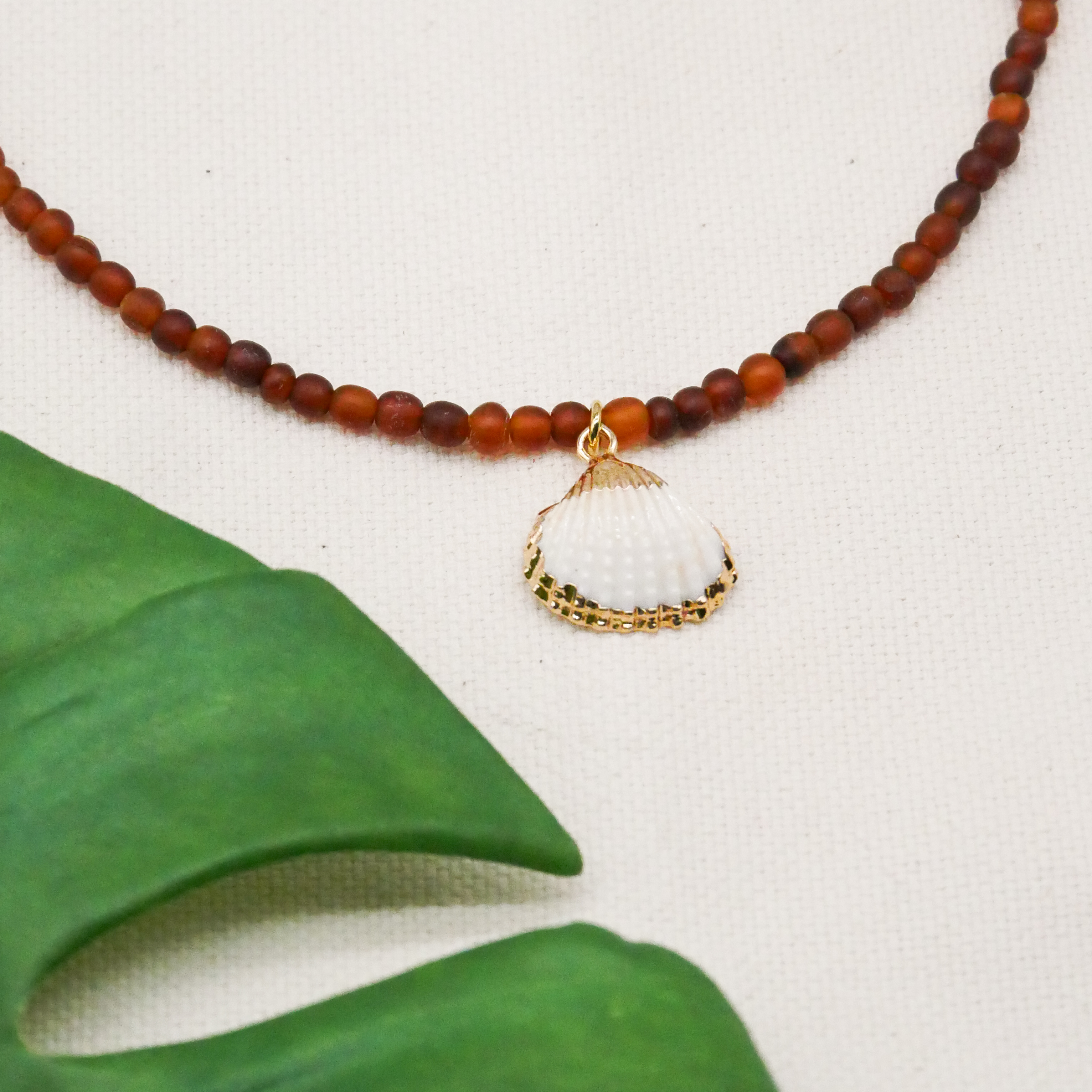  "Shell" kurze Kette, kleine Carabo Horn Perlen Ø ca. 5 mm, dunkles braun, Muschelanhänger 
